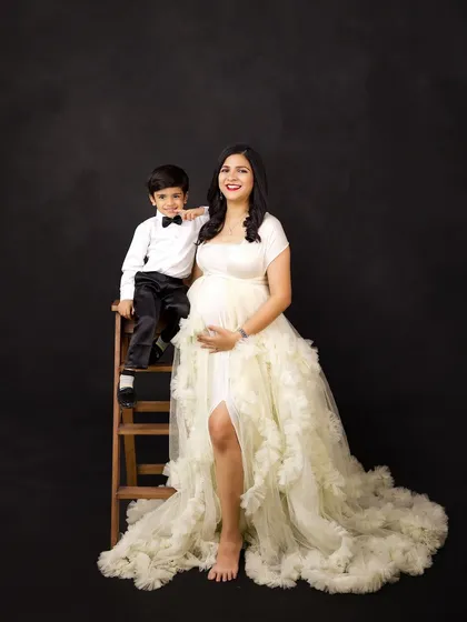 A beautiful portrait of a mother-to-be with her son. The flowing white gown and the loving interaction create a soft and elegant maternity photo.
