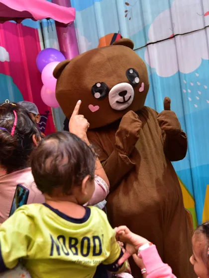 A toddler meets our friendly bear mascot. These gentle giants are always a huge hit with the youngest guests, providing lots of hugs and great photo moments.