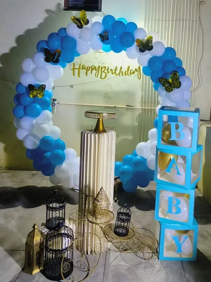 A simple yet beautiful blue and white balloon ring decorated with golden butterflies, perfect for an elegant and budget-friendly birthday at home.