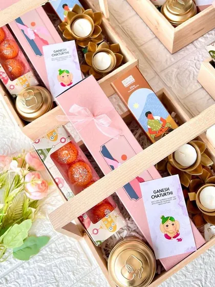 A closer look inside our Ganesh Chaturthi hamper, showing the motichoor laddoos and lotus-shaped diyas.