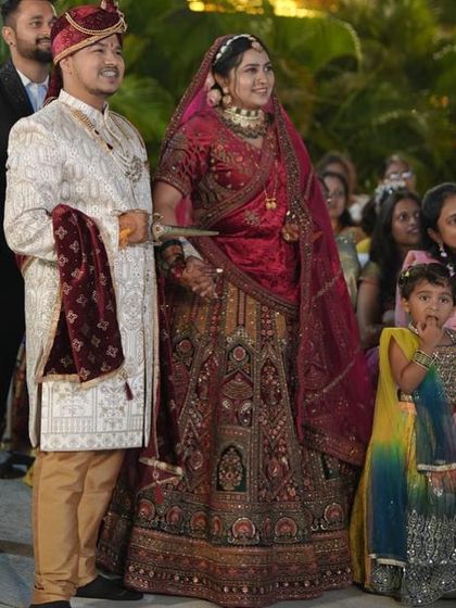 A beautiful bride captured mid-ceremony. Her traditional red and gold lehenga shines, showing the intricate details that make it so special.
