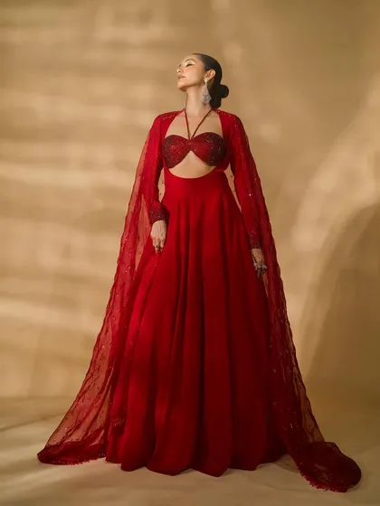 An ethereal shot of a model in a red ensemble from Nikhil Thampi's 'Scarlet Edit'. The lighting from below and the upward gaze create a majestic and powerful portrait.