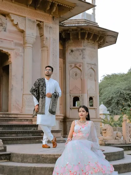 A regal pose on the steps of a historic monument. This composition gives a sense of grandeur and elegance, perfect for a royal-themed pre-wedding photoshoot.