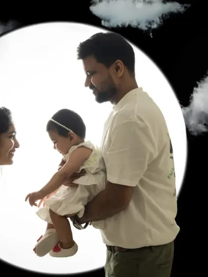 A creative edit of a backlit family portrait, placing them among the clouds against a full moon for a dreamy and magical effect.