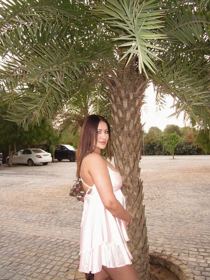 A light pink backless babydoll dress, perfect for a warm day at a farmhouse or a picnic.