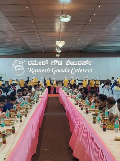 The symmetrical arrangement of tables at a large event hall, ready for our grand feast. We handle all aspects of the dining setup.