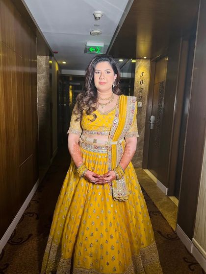 A full-length view of this soft and glowing minimalistic look. The yellow lehenga is perfect for a daytime event, and the makeup is fresh and light.