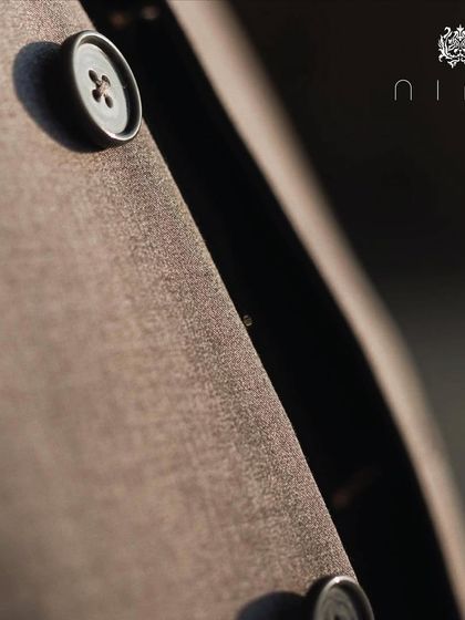 A close-up on the lapel and buttons of a classic suit. Every detail, no matter how small, is considered.
