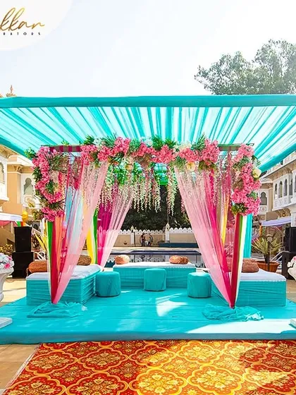 A beautiful Haldi or Mehendi seating area by the pool, decorated in shades of turquoise and pink. The setup is both colorful and elegant, perfect for a day event.
