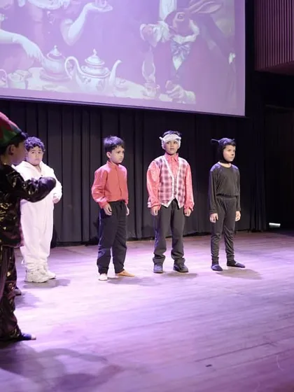 The cast of 'The Elves and the Shoemaker' on stage. The use of costumes and simple set pieces helps create the world of the play.