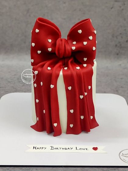 A romantic gift box cake with a big red bow dotted with tiny hearts. A perfect way to say "Happy Birthday Love."