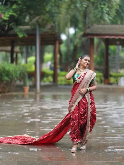 Make a grand entrance with this beautiful red bandhani-style Nauvari. The long, flowing 'shetar' or trail adds a touch of royal elegance, ideal for pre-wedding photoshoots or for a bride who wants a dramatic look.