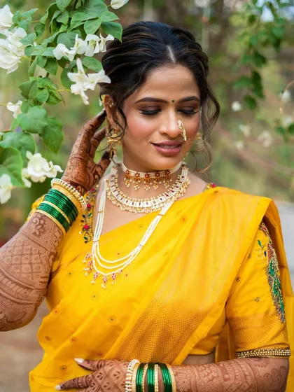 A serene moment amidst white flowers. The yellow of her saree and the warmth of her makeup create a beautiful contrast with the surroundings.