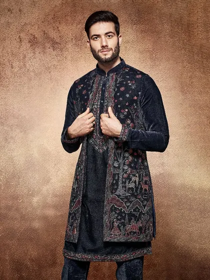 This navy blue velvet jacket is adorned with intricate, narrative-style embroidery. Paired with a matching kurta, it creates a look that is both regal and rich in artistry.