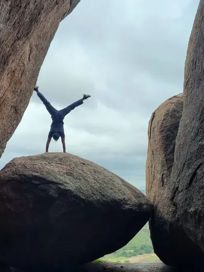 Akash doing a handstand on a perched boulder, a playful display of his strength, balance, and love for the outdoors.