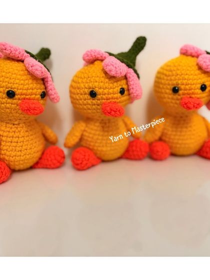A trio of my handmade ducks, each with a pink flower on its head.