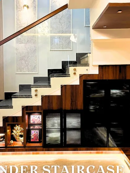 Every inch of space has potential. Here, we transformed the often-overlooked area under the staircase into a beautiful and functional display unit. This custom-built solution provides a perfect spot for showcasing family photos, art, and decor, adding a personal touch to the home.