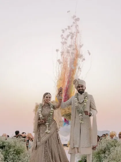 A couple celebrates their union with a burst of rainbow-colored smoke at their destination wedding in Kochi. The backwaters provide a serene and unique setting for the celebration.