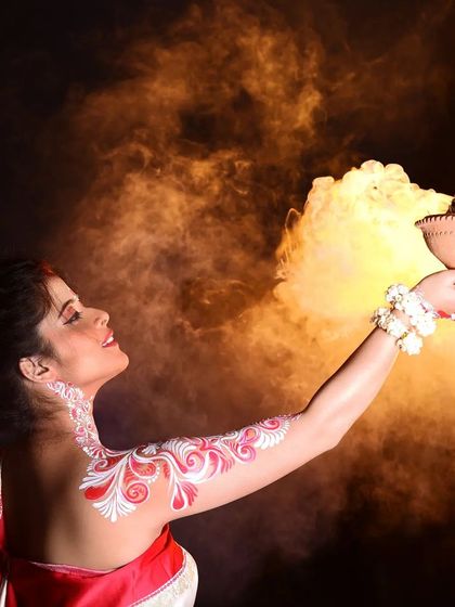A creative shot from the Bengali-themed series, featuring the model with a traditional dhunuchi for a Durga Puja concept. The makeup and body art remain flawless amidst the dramatic smoke.