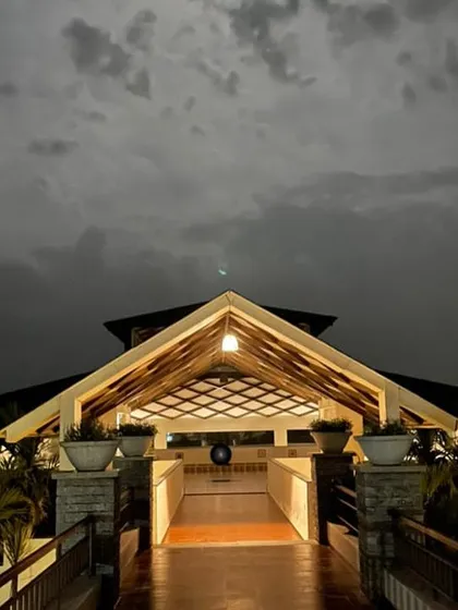 As dusk settles, the retreat transforms into a tranquil haven. The warm lights of our main hall offer a welcoming glow against the dramatic night sky, creating a perfect atmosphere for evening meditation.