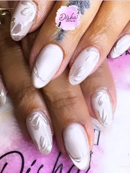 Subtle elegance meets soft shimmer. These pearl-toned nails with delicate leaf details are all about timeless grace.