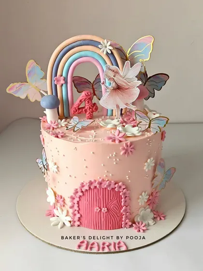 A whimsical fairy cake that's a pastel dream come true. This design features a delicate fairy, a soft rainbow, and fluttering butterflies, with a charming pink door to the fairy house.