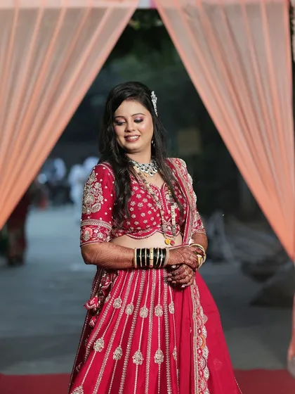 The smile of a bride who found her perfect look. This red lehenga with intricate work is a popular choice for its classic and celebratory feel.