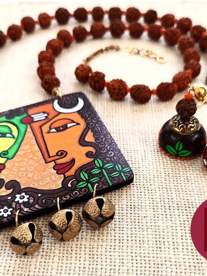 A detailed view of the Shiva Shakti set, focusing on the intricate artwork on the pendant and the matching hand-painted wooden jhumkas.