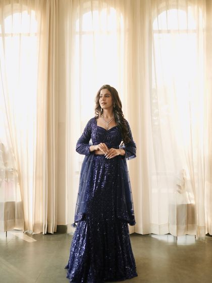 A three-quarter shot that focuses on the detailed sequin work and the flattering silhouette of the lehenga.
