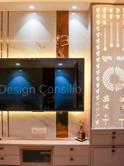 Here you can see how we integrated a custom mandir into the living room's main TV and storage unit. The jali door design is backlit, turning it into a beautiful feature when lit.