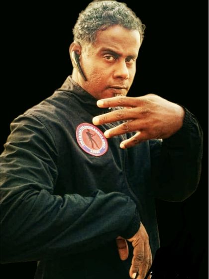 A portrait capturing the focus and readiness of a martial artist. The hand is ready to block or strike, and the eyes are watchful.