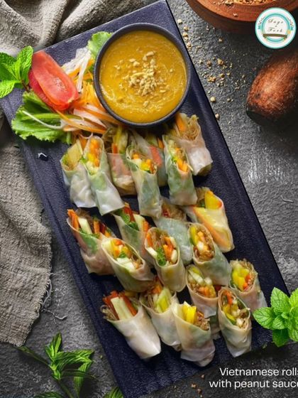 A close-up of our fresh and light Vietnamese rolls, served with a creamy peanut dipping sauce. These are perfect for a healthy snack or a light bite at any event.
