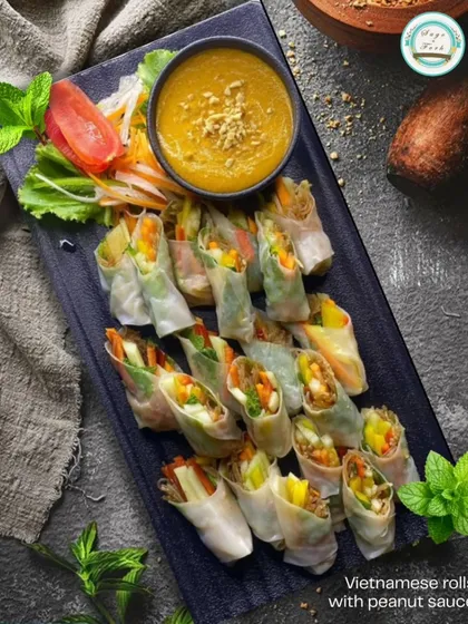 A dark and moody shot of my Vietnamese rolls, emphasizing the fresh mint and vibrant vegetables. The peanut sauce is the perfect accompaniment.