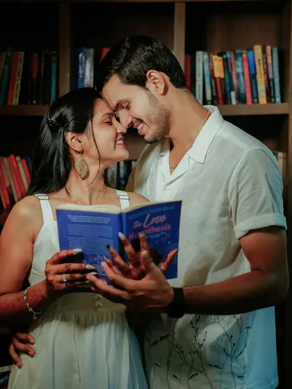 A romantic moment shared over a book. This close-up from a library-themed shoot captures the sweet and intimate connection between Suchita and Om Prakash.
