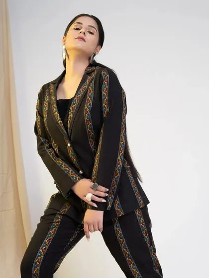A strong, angled shot of the black pantsuit, highlighting the sharp tailoring and the model's commanding presence. This type of image is great for conveying a brand's bold identity.