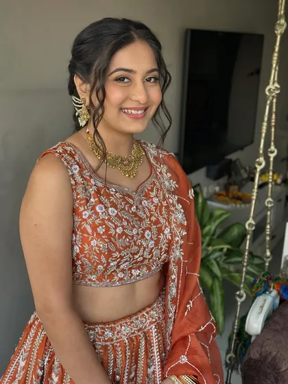 A happy, smiling bride. The clean makeup look enhances her features without feeling heavy, perfect for a high-energy Garba night.
