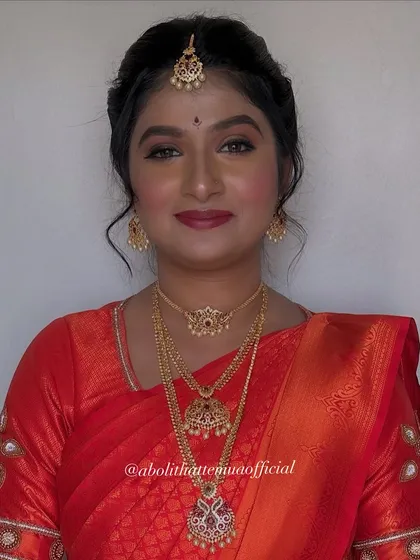 A close-up of the South Indian bridal makeup. The look features defined eyes, glowing skin, and traditional jewelry like the choker and layered necklaces.
