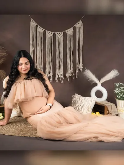 This candid-style shot captures a quiet moment of reflection. The warm, earthy setup with natural textures provides a perfect backdrop for capturing the peaceful and introspective side of pregnancy.