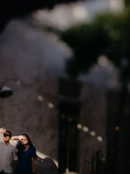 An artistic shot of a couple shielding their eyes from the sun in a narrow Dubai alley. The creative use of light and shadow makes this a unique and memorable pre-wedding photo.