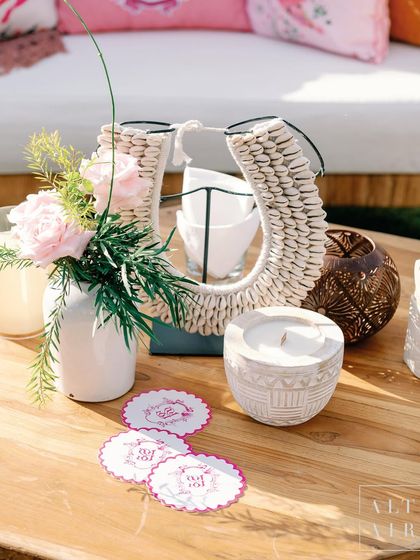 Details on a coffee table at 'Villa Brissa', including custom coasters and a shell-decorated artifact. We love styling with thoughtful details that enhance the overall mood.