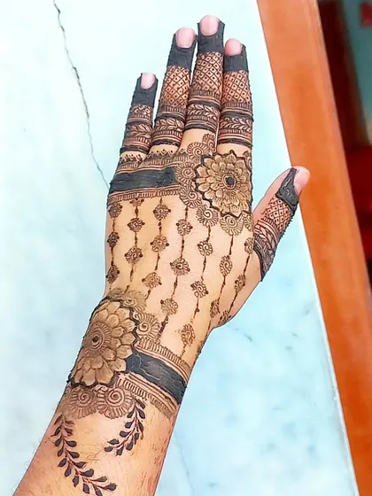 A full-hand design that prominently features a 'jaali' or net pattern. The precision required for this work is something I take great pride in.