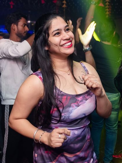A huge smile that says it all. The music is good, the vibe is right, and the night is young.
