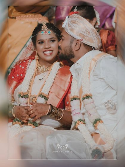 A sweet, candid moment of the groom whispering to his smiling bride during their wedding ceremony.