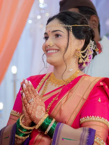 A moment of reverence during the ceremony. This image shows the bride's serene expression and the traditional headpiece, or 'mundavalya', which is a key part of the wedding ritual.