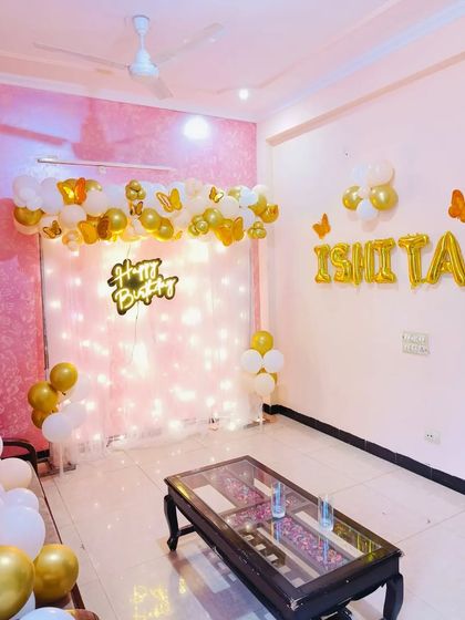 A wider view of the elegant "ISHITA" birthday setup, showing how it transforms a living room into a beautiful, celebratory space.
