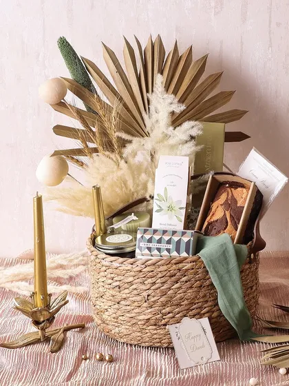 Our Cottage Charm Hamper brings a rustic, cozy feel to Diwali. It's packed with a marble tea cake, cookies, chocolate truffles, and scented candles in a beautiful wicker basket.