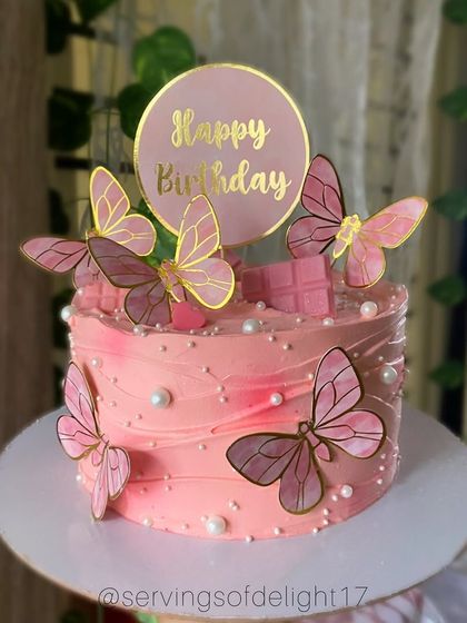 A pretty pink birthday cake with textured buttercream and delicate butterfly toppers. This is a popular choice for a feminine and graceful celebration.
