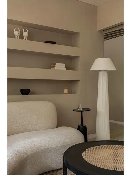 In this wellness lounge, we used a palette of soft, creamy tones and curved forms to create a space that feels both luxurious and deeply calming. The design features a custom bouclé sofa, built-in shelving niches, and carefully selected lighting to establish a serene atmosphere for clients.