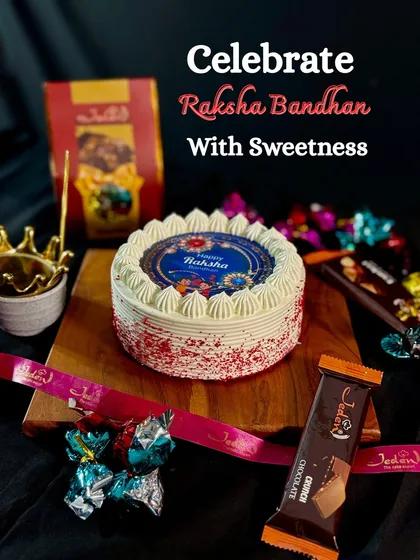 Celebrate the special bond of Raksha Bandhan with a gift that’s as sweet as your memories. This setup features a beautiful designer cake with a Rakhi theme, surrounded by our signature chocolates and gift packs.