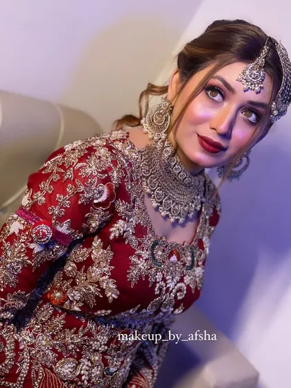 A stunning portrait of a bride in red. Her eyes are the focus, with a beautiful cut-crease look, complemented by a classic red lip.